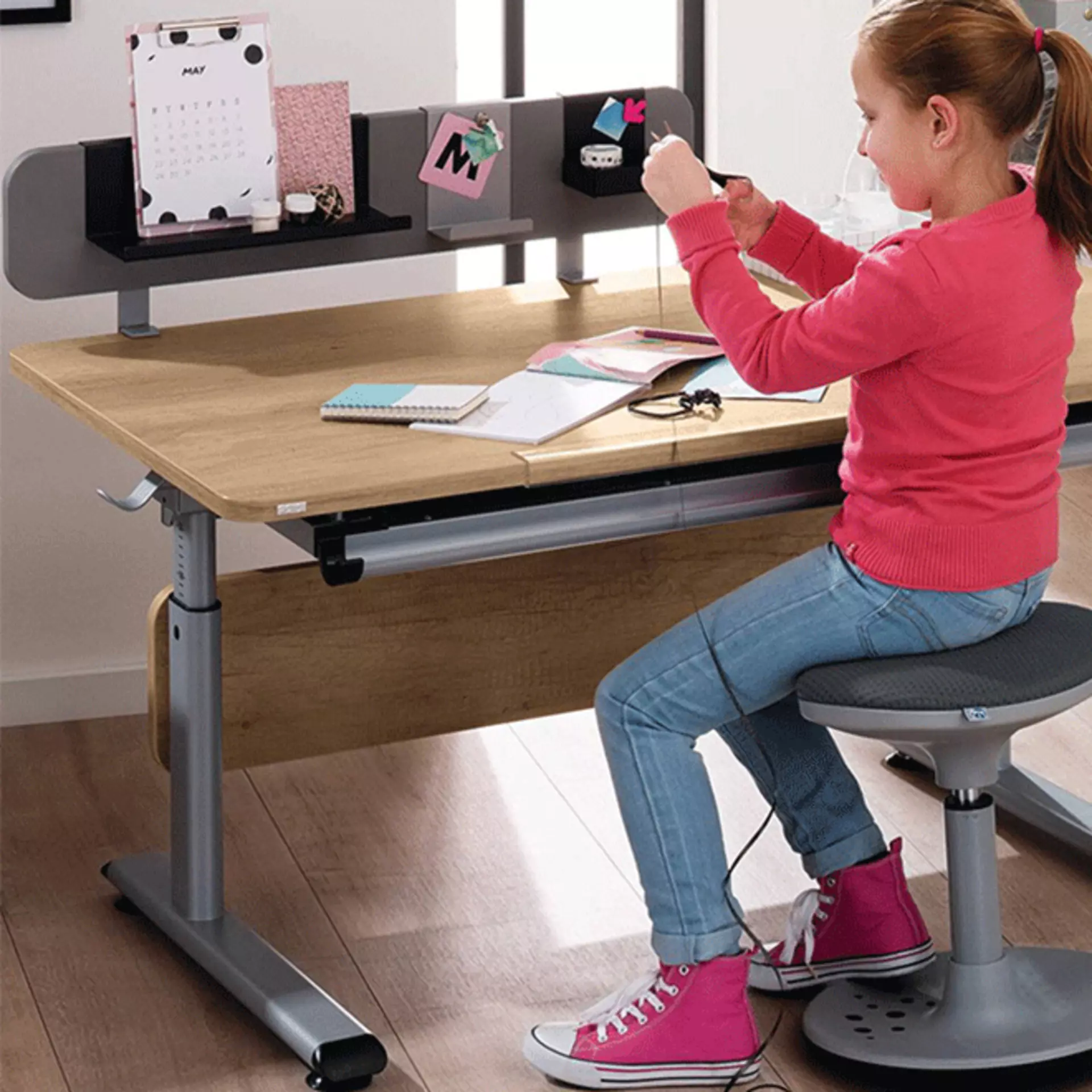 Kleines Mädhcen am Basteln an ihrem schreibtsich