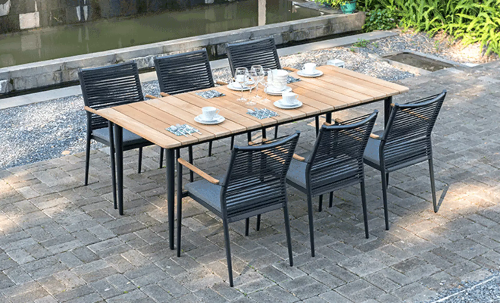 Gedeckter Esstisch mit Schwarzen Stühlen im Garten