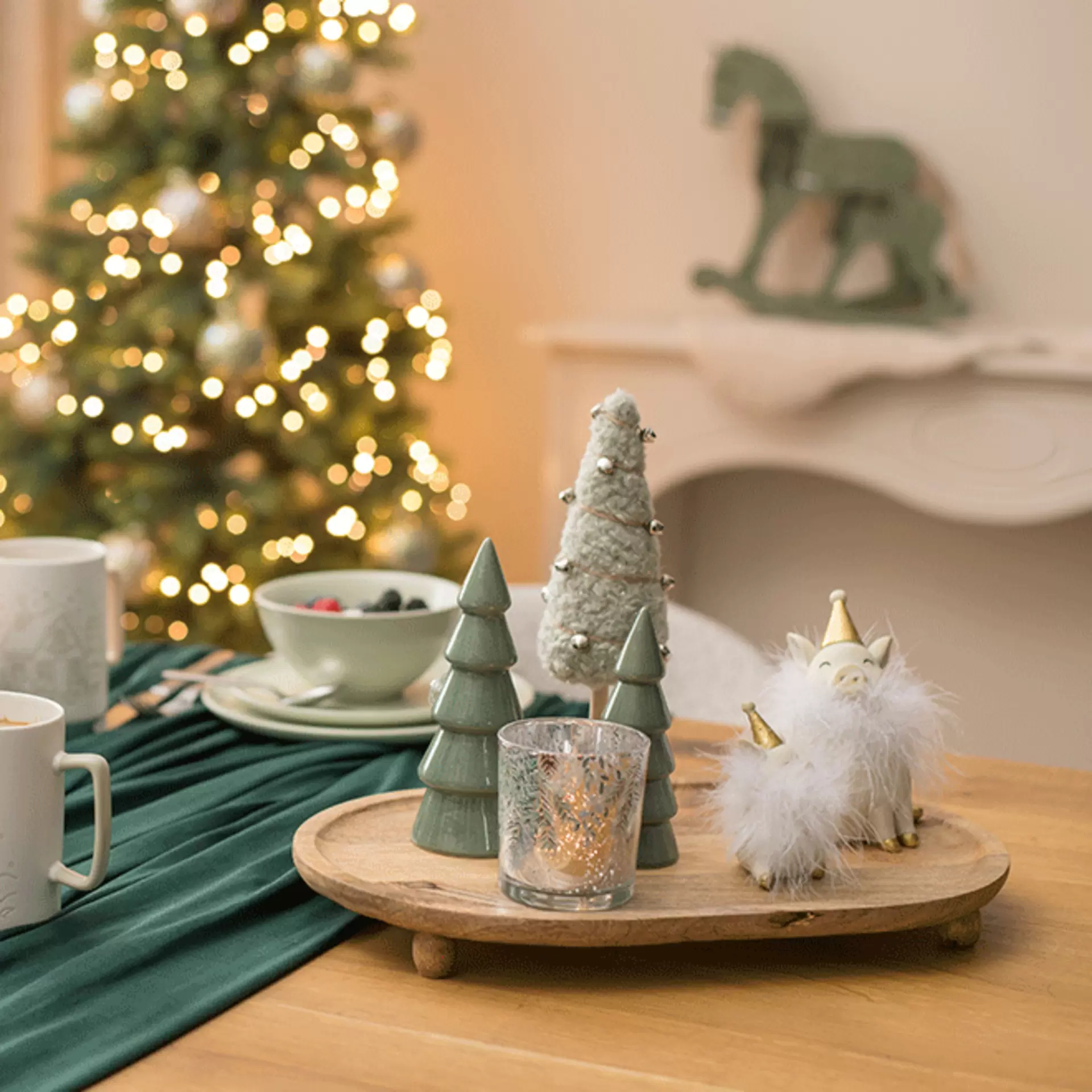 Skandinavische Weihnachtsdeko auf einem Holztablett mit feinen Deko-Tannenbäumen
