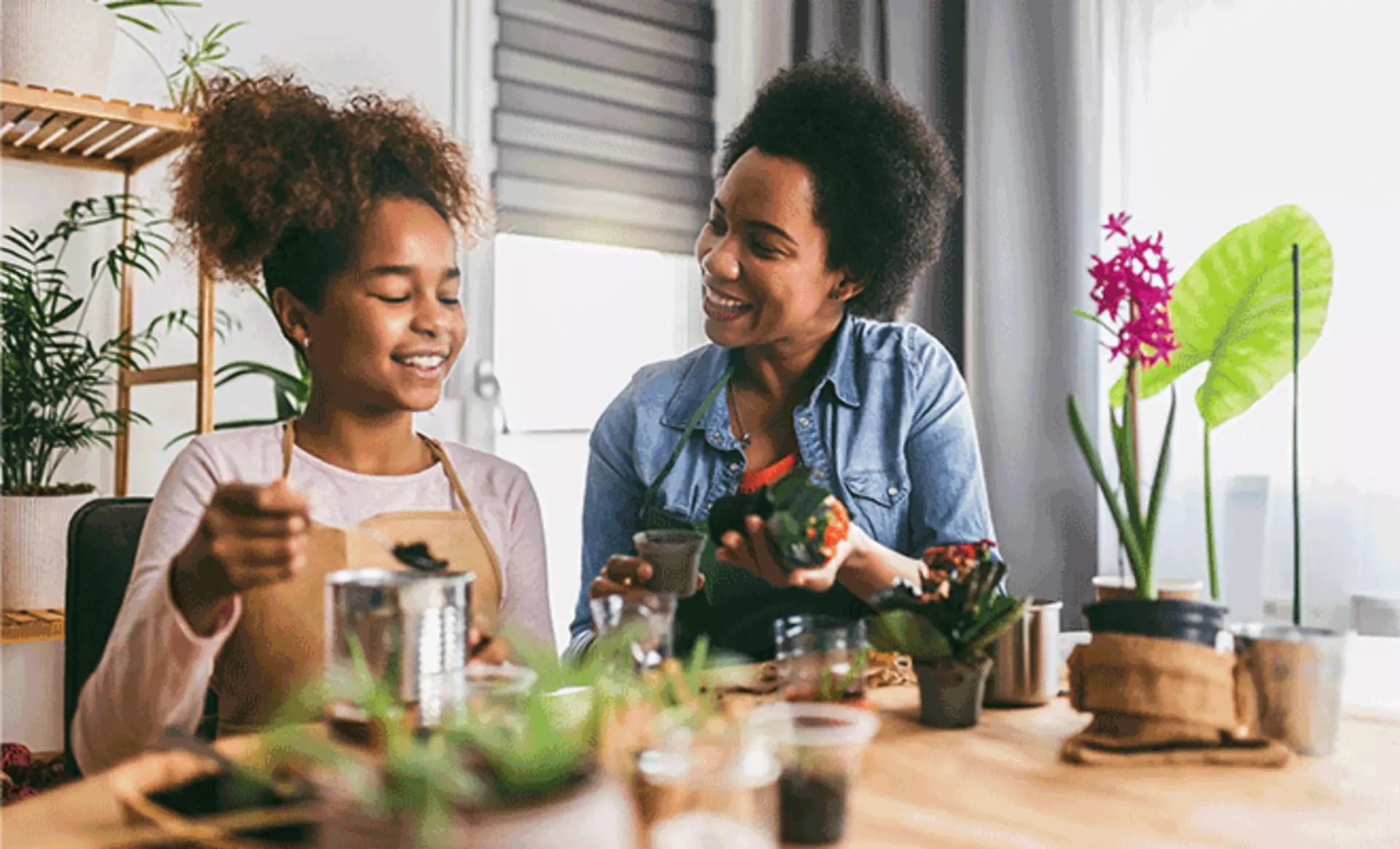 Mutter und Kind pflanzen gemeinsam Blumen und Pflanzen zu Hause.