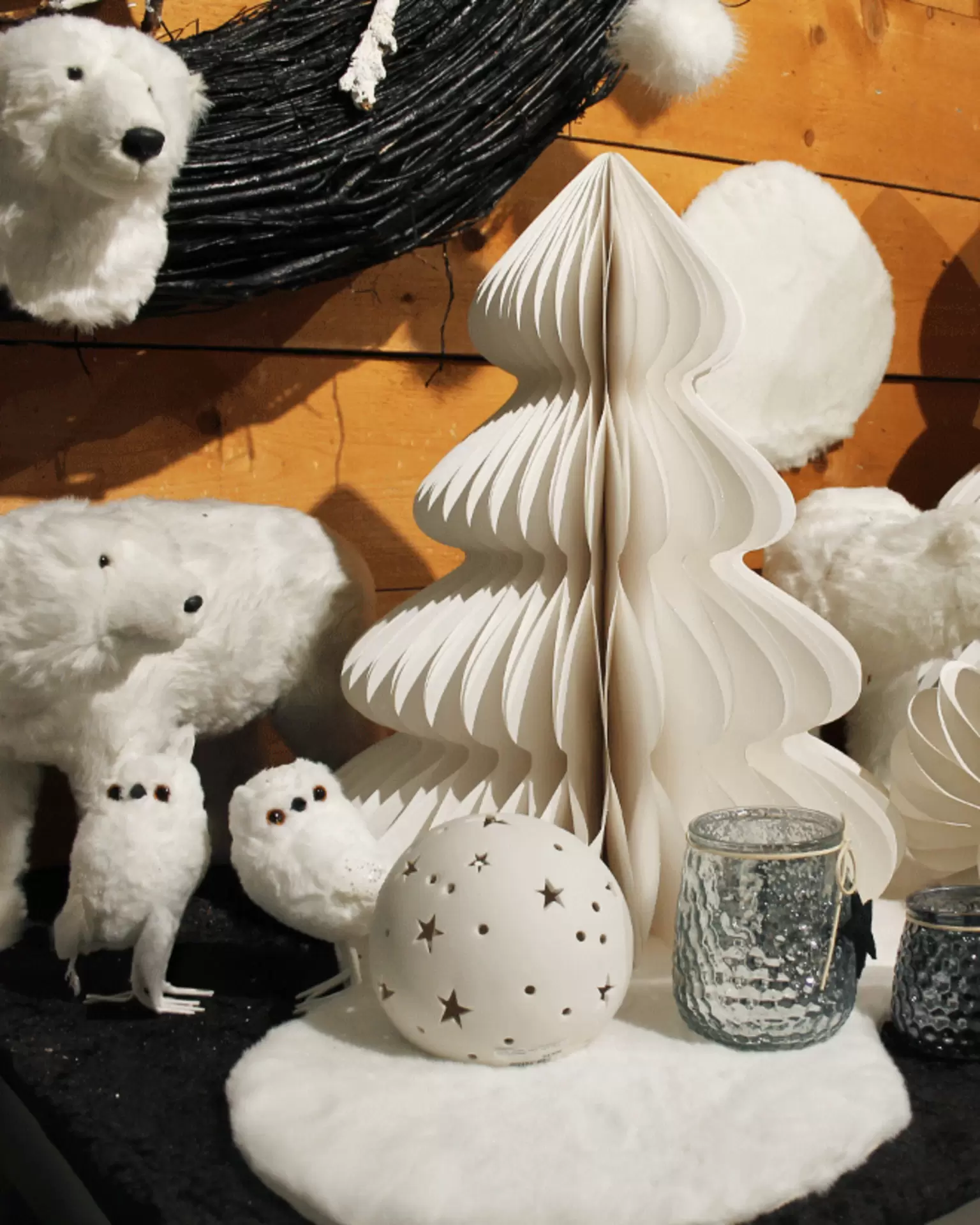 Moderne Weihnachtsdekoration aus weißen Papier-Tannenbäumen, Dekokugeln und Eisbärenfiguren